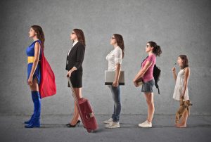 Five females lined up starting with a girl and increasing in age and work status to become Super Woman.